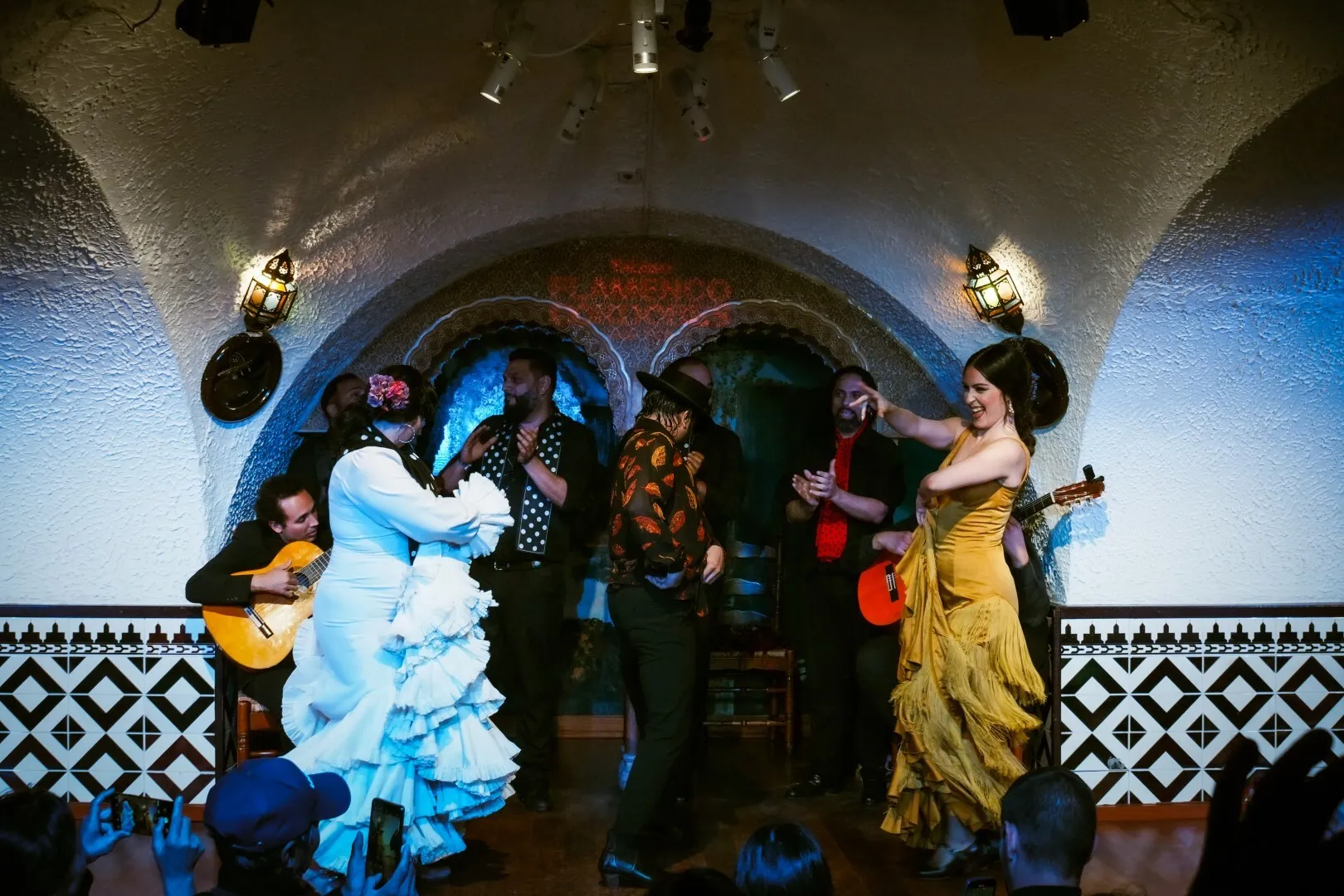 Flamenco performers in a white and yellow dress